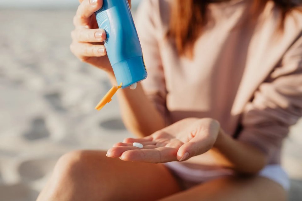 Applying sunscreen on the hand outdoors